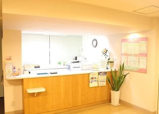 みねおい内科・循環器内科医院 松山駅(愛媛県) 観葉植物をおき、やわらかな雰囲気で明るい受付ですの写真